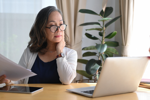 Asian woman with glasses watching a webinar 